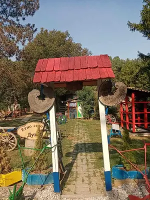 a playground with a red roofed structure in a park at Etno selo Dukat in Belo Polje