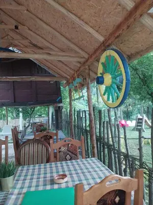 a dining room with a table and a wheel hanging from the ceiling at Etno selo Dukat in Belo Polje