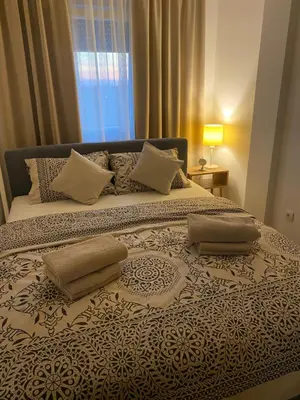 a bedroom with a large bed with pillows on it at Green Lux Apartment in Inđija