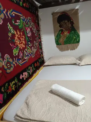a bed in a room with a painting on the wall at Etno selo Dukat in Belo Polje