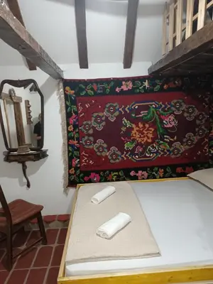 a table in a room with a rug on the wall at Etno selo Dukat in Belo Polje