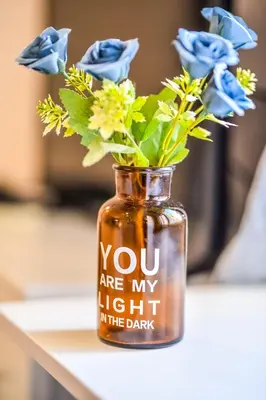 a jar with flowers in it sitting on a table at Panorama Central-Downtown Studio in Belgrade
