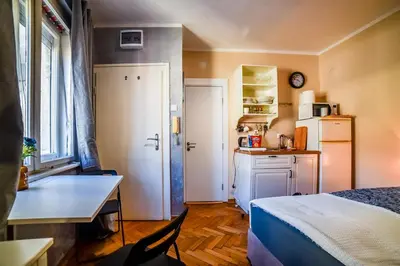 a small room with a bed and a table and a kitchen at Panorama Central-Downtown Studio in Belgrade