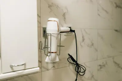 a white blow dryer on a wall in a bathroom at Apartman Premijer 2 in Čukarica