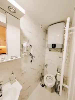 a white bathroom with a toilet and a sink at Apartman Premijer 2 in Čukarica