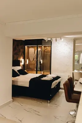 a bedroom with a large bed and a chair at Apartman Premijer 2 in Čukarica