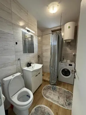 a bathroom with a toilet and a sink and a washing machine at KALEMEGDAN Apartment - Belgrade in Belgrade