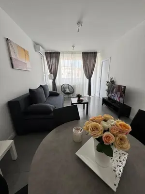 a living room with a vase with flowers on a table at LUNI Apartmants Vracar in Belgrade