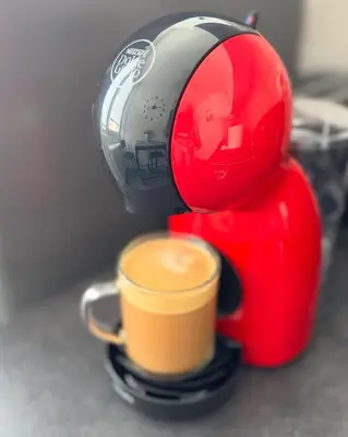 a red and black coffee maker with a cup of coffee at LUNI Apartmants Vracar in Belgrade
