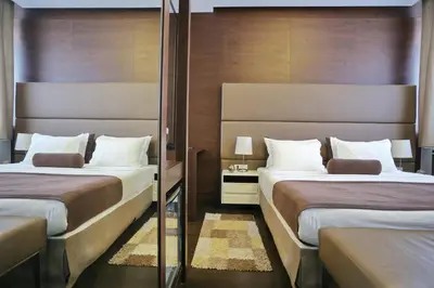 a hotel room with two beds and a mirror at Belgreat Premium Suites in Belgrade