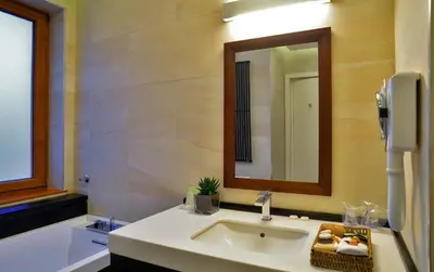 a bathroom with a sink and a mirror and a tub at Belgreat Premium Suites in Belgrade