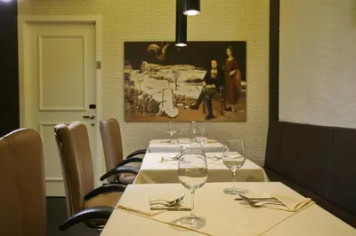 a table in a restaurant with wine glasses on it at Belgreat Premium Suites in Belgrade