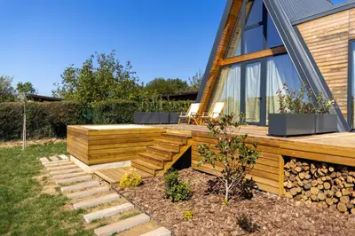 a house with a wooden deck and stairs in a yard at SunMoon Kosmaj kućice i prostor za događaje in Sopot