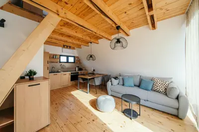 a living room with a couch and a kitchen at SunMoon Kosmaj kućice i prostor za događaje in Sopot