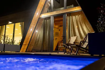 a house with a swimming pool at night at SunMoon Kosmaj kućice i prostor za događaje in Sopot
