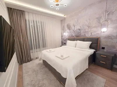 a bedroom with a large bed with a white blanket at Premium Simfonija Apartment in Belgrade