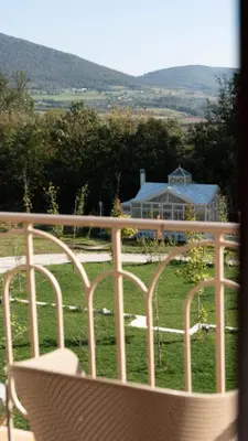 a balcony with a view of a house and a field at Hyde Hill Kosmaj in Sopot