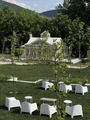 a group of white tables and chairs in a field at Hyde Hill Kosmaj in Sopot