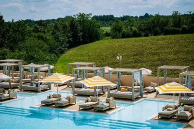 an outdoor pool with umbrellas and lounge chairs at Hyde Hill Kosmaj in Sopot