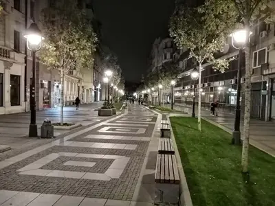 a city street at night with benches and lights at VANSVEL Boutique Apartment 12 in Belgrade