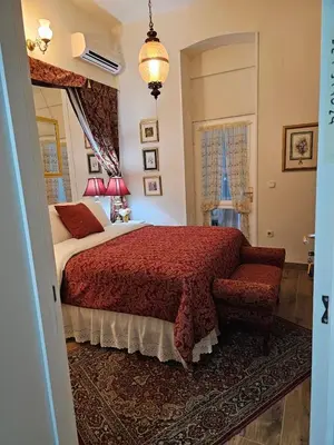 a bedroom with a bed with a red blanket and a chair at VANSVEL Boutique Apartment 12 in Belgrade