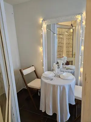 a table with a white table cloth and a mirror at VANSVEL Boutique Apartment 12 in Belgrade