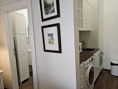 a kitchen with white cabinets and a washer and dryer at VANSVEL Boutique Apartment 14 in Belgrade