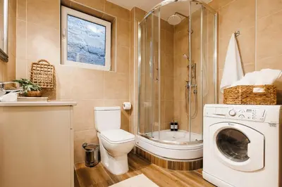 a bathroom with a toilet and a shower and a washing machine at Pintrst-Penthouse 110m2 Ping Pong Old Town in Belgrade