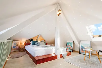 a bedroom with a large bed in a attic at Pintrst-Penthouse 110m2 Ping Pong Old Town in Belgrade