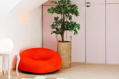 a orange chair next to a plant in a room at Pintrst-Penthouse 110m2 Ping Pong Old Town in Belgrade