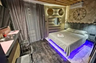 a bedroom with a bed with a clock on the wall at Dorcol Downtown Studio in Belgrade