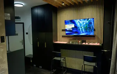 a bar with chairs and a tv on a wall at Dorcol Downtown Studio in Belgrade