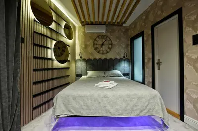 a bedroom with a bed with a clock on the wall at Dorcol Downtown Studio in Belgrade