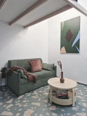 a living room with a green couch and a table at Studio MAXIM in Vračar (historical)