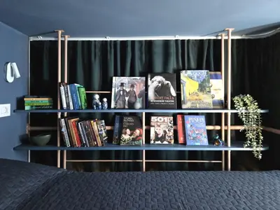 a book shelf with books on it next to a bed at Studio MAXIM in Vračar (historical)