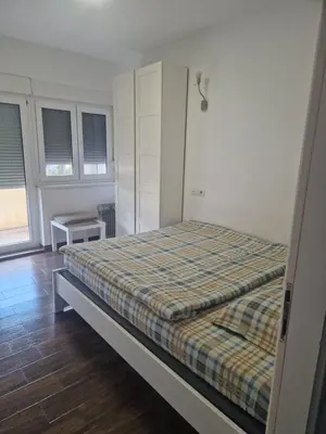 a bedroom with a bed with a plaid blanket at Centro apartman 2 in Pančevo