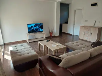 a living room with a couch and a tv at Centro apartman 2 in Pančevo