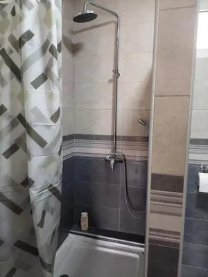 a shower with a glass door in a bathroom at Centro apartman 2 in Pančevo