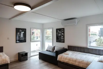 a living room with a couch and two windows at REAL Suites in Ledine
