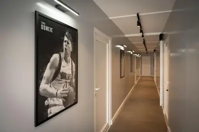 a hallway with a framed picture of a basketball player on the wall at REAL Suites in Ledine