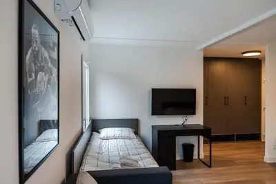 a small room with a bed and a tv at REAL Suites in Ledine