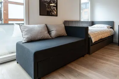 a bed and a couch in a bedroom at REAL Suites in Ledine
