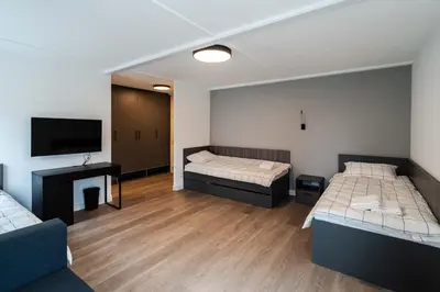 a room with two beds and a flat screen tv at REAL Suites in Ledine