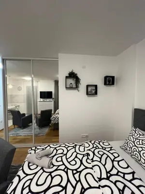 a bedroom with a bed and a living room at Studio 54 in Belgrade