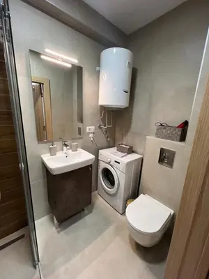 a bathroom with a toilet sink and a washing machine at Studio 54 in Belgrade