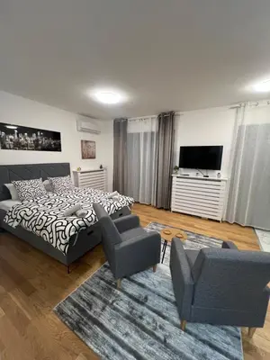 a bedroom with a bed and chairs and a television at Studio 54 in Belgrade