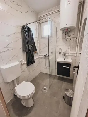 a white bathroom with a toilet and a sink at Prenoćište Katarina JUGOVO in Smederevo