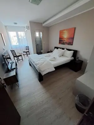 a bedroom with a large bed and a table and chairs at Prenoćište Katarina JUGOVO in Smederevo