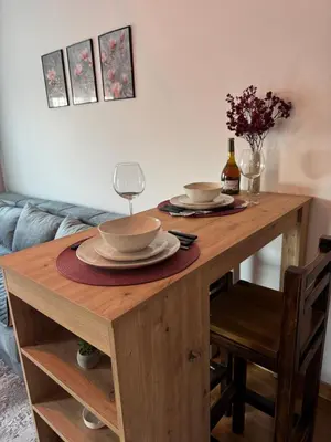 a wooden table with two plates and a wine glass at Studio29 2 in Ruma