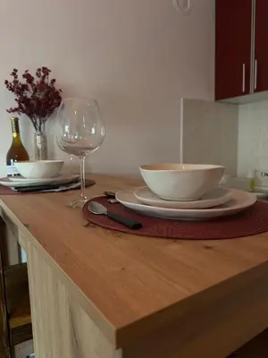a table with two bowls and a wine glass on it at Studio29 2 in Ruma